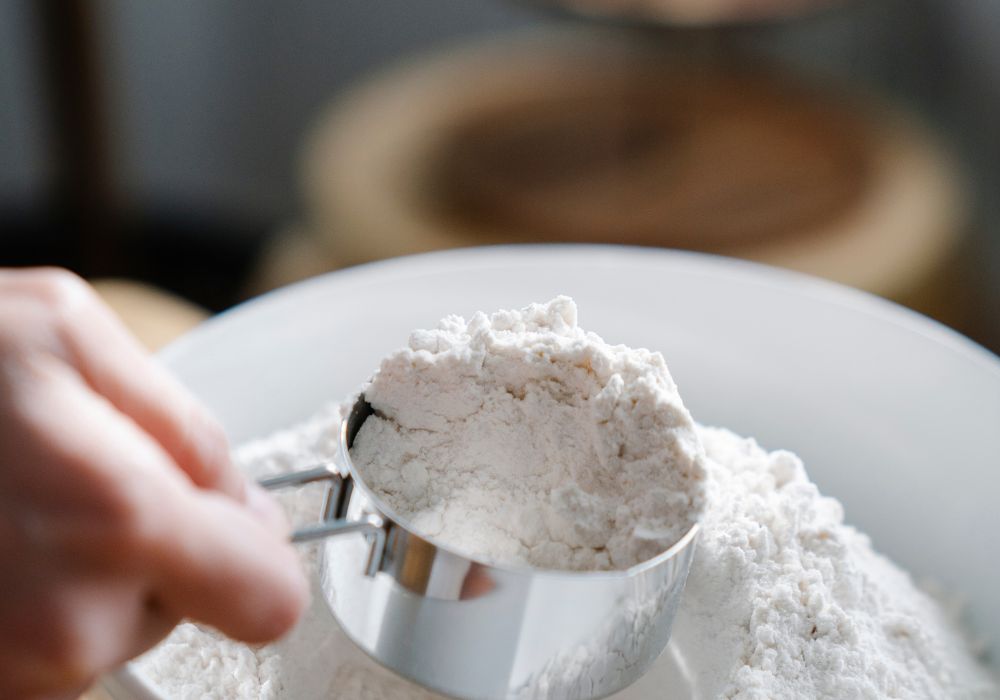 Person Scooping Flour with a Measuring Cup for a dry measurement